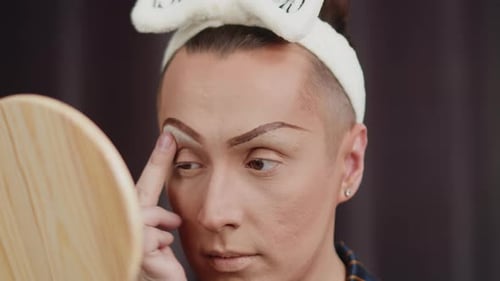 Applying Makeup to Face in Mirror at Home