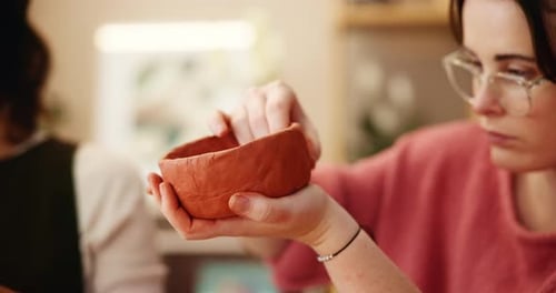 Young Woman Shaping Clay Bowl with Fingers