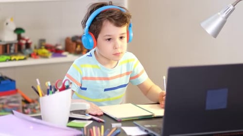 Young Boy Studying with Laptop and Headphones