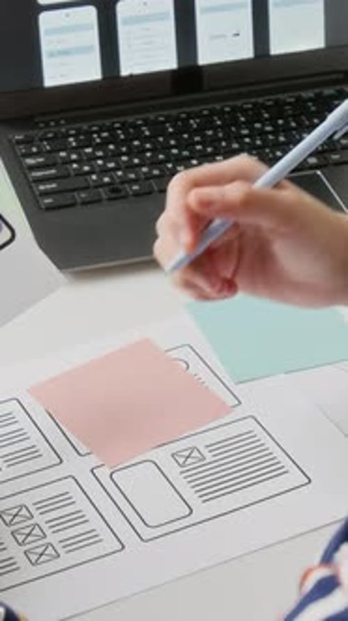 Woman Designs Mobile App Interface at Desk