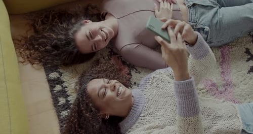 Smiling Women Take Selfie Lying on Rug