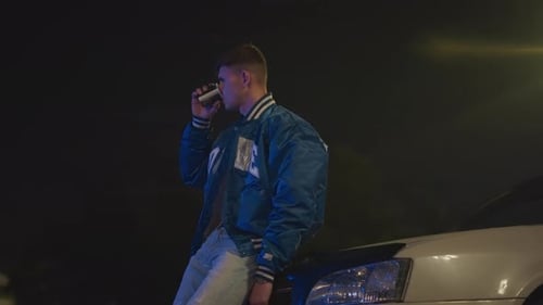Man Drinking Outside at Night Near Car