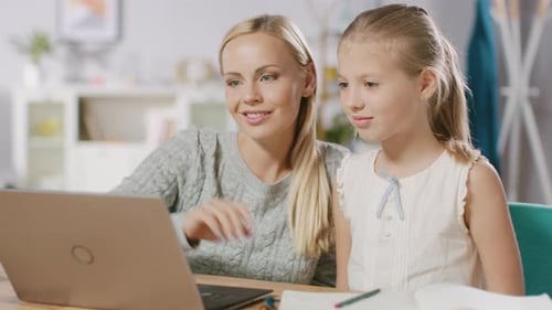 Bright Little Girl Studies with Her Lovely Young Mother Study School Lessons at Home. Dedicated Mom