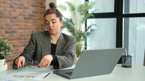 Exhausted Businesswoman in Office Takes Off Glasses to Relieve Headache