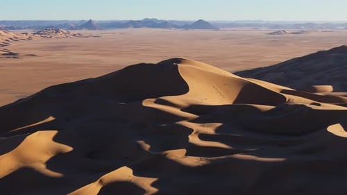 A breathtaking aerial view of the Sahara Desert's towering golden sand dunes, showcasing nature's ra