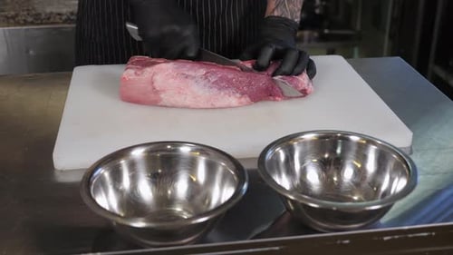 Chef Cutting Raw Meat on White Cutting Board