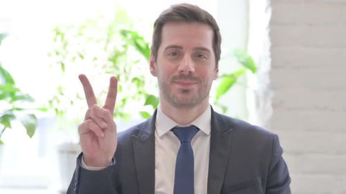 Smiling Man in Suit Makes Peace Sign
