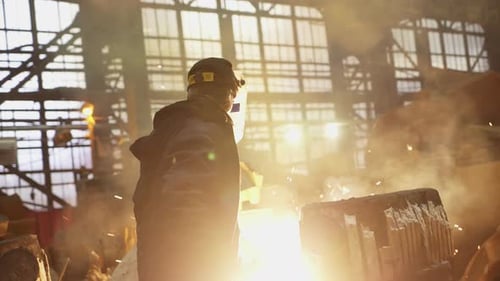 Industrial Workers Grinding Metal With Flying Sparks