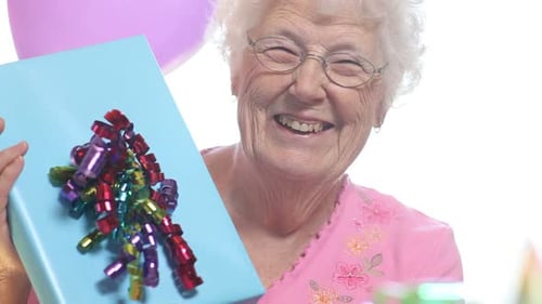 Senior woman smiling and holding a gift