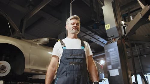 Car Service Station Middle Age Grey Haired Mechanic Man or Smith Repairing Car