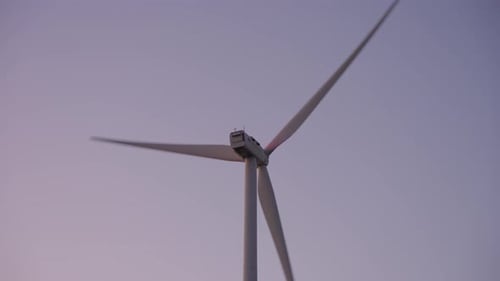 Windturbine in einem großen Windpark. Große Windturbine im Feld vor Sonnenuntergang am Horizont. Erneuerbar