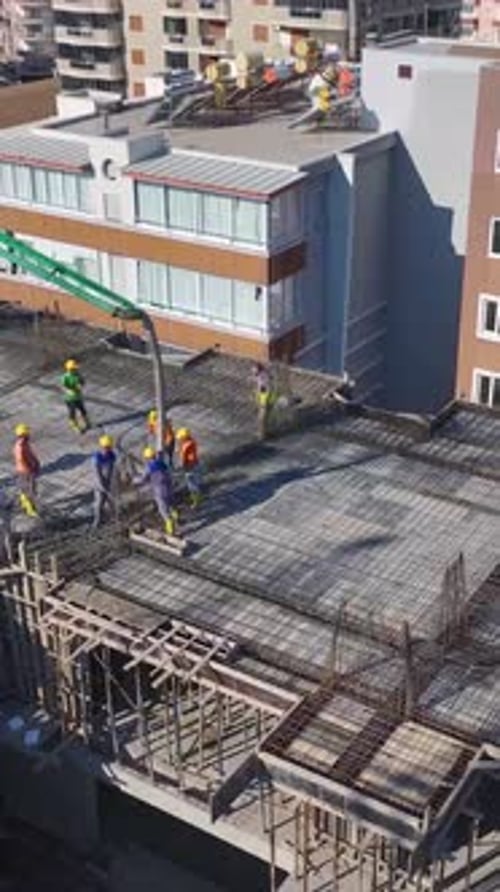 Vertical Video of Workers Building Walls While a Crane Moves Heavy Materials on a Residential Site