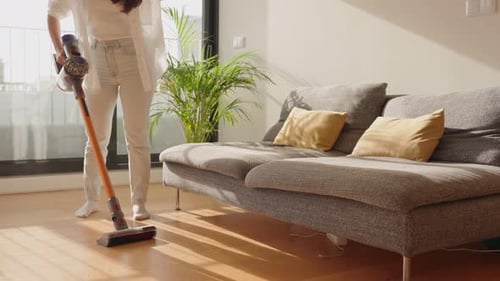 Woman Vacuuming the Floor in Living Room