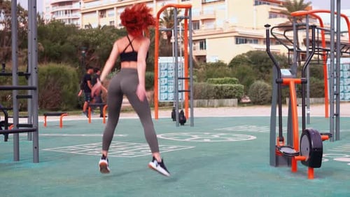 Determined Fit Woman Doing Squats and Jumping at Outdoor Gym