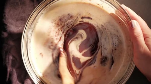 Topview of stirring cream and butter with wooden spoon