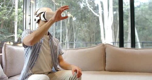 Young Adult Interacting with Virtual Reality Headset Indoors