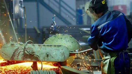 Metal Worker Using Angle Grinder on a Range Hood