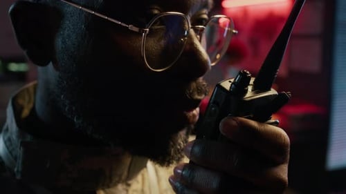 Man Talking into Walkie Talkie at Night