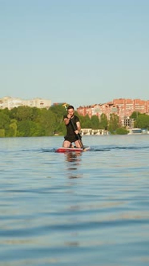 Kneeling Man Paddling on Stand Up Paddle Board