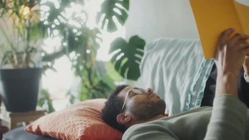 Man Relaxing Reading a Book on the Couch