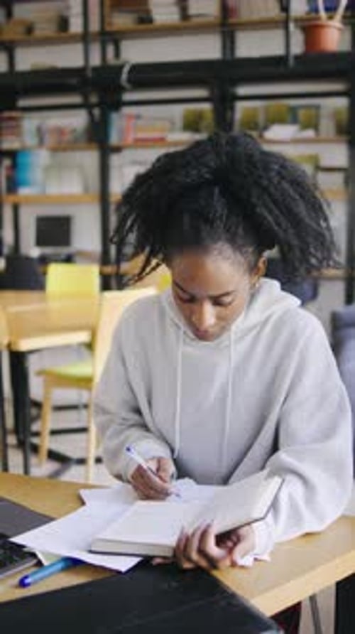 Focused Student Studying with Laptop and Book