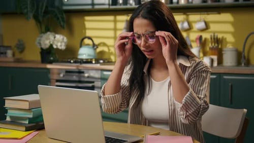 Tired Overworked Latina American Woman Studying at Home on Laptop Removing Glasses Exhausted Student
