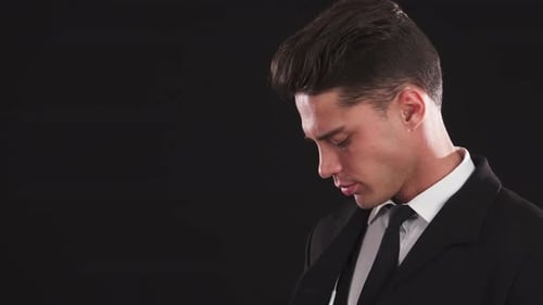 Man Puts In Earbud With Black Background