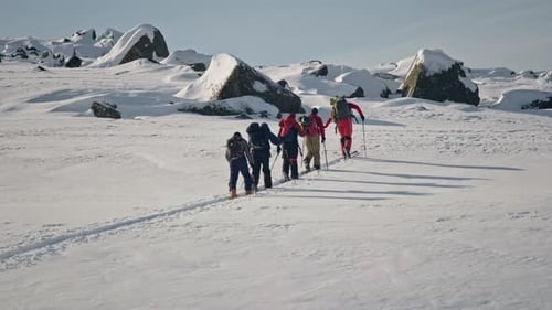 Ski Touring Mountaineers Ascending Snowy Mountain Slope