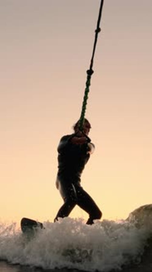 Man Kitesurfing at Sunset in Ocean Waves
