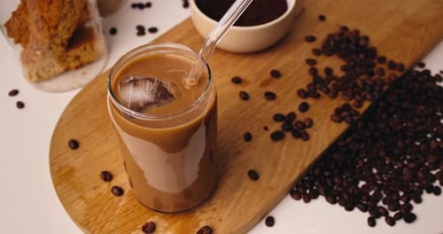 Iced Coffee Drink Being Poured on Wooden Board