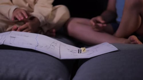 un niño y una niña juegan un juego de mesa en una casa improvisada en el apartamento