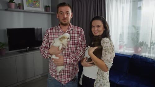 Couple Holding Dogs in Living Room