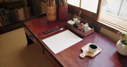 Art, paper and calligraphy tools in artist studio with creative brushes