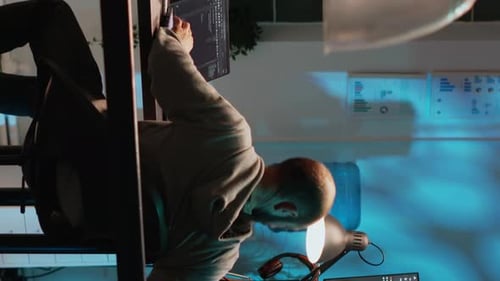 Man Coding on Multiple Screens at Night