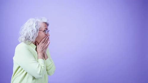 Une femme âgée expressive réagit avec des gestes surpris