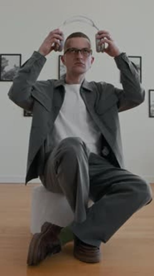 Vertical Shot Man setzt in der Kunstgalerie große Kopfhörer auf