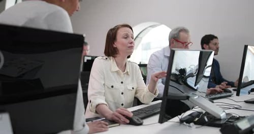 Team Working Together at Computers in Bright Office