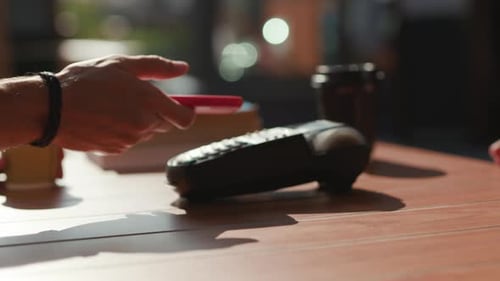 Close Up Man Paying with NFC Technology with Smart Phone Credit Card Application in Cafe Coffee