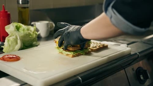 professional kitchen in a restaurant the chef lays out the ingredients for a club sandwich on toast
