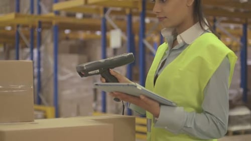 MS TU Young woman using barcode reader and digital tablet in factory warehouse