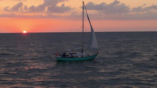 Cinematic Aerial Wide Shot of a Sailboat Sailing s on Deep Water on Sunset Time
