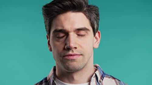 Young Adult Man's Close Up Portrait on Blue