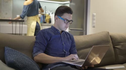 Young Teenager Working on Laptop on Sofa at Home Adolescent