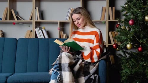 Woman Enjoys Reading a Book at Christmas Time