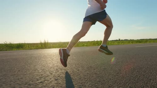 Man Wearing Shorts Tshirt and Sneakers Running Fast in Road