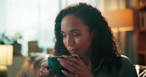 Woman, smell coffee and smile on sofa with aroma, scent and relax with thinking in lounge at home