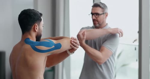 Physiotherapy, shoulder stretching and man patient with sport massage therapist at clinic