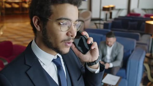 Busy Entrepreneur Talking on Mobile Phone with Client