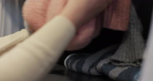 Woman Organizing Clothes in Wardrobe Housewife and Housekeeping Hacks Cleaning on the Shelves in the