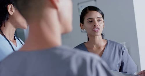 Diverse doctors and nurses talking in corridor at hospital, in slow motion